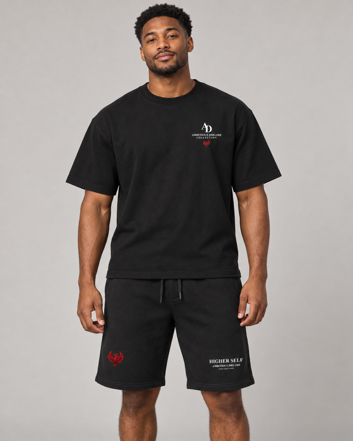 AI model mockup showing the Ambitious Dreamz black boxy tee and Higher Self shorts, front view. Pieces sold separately.